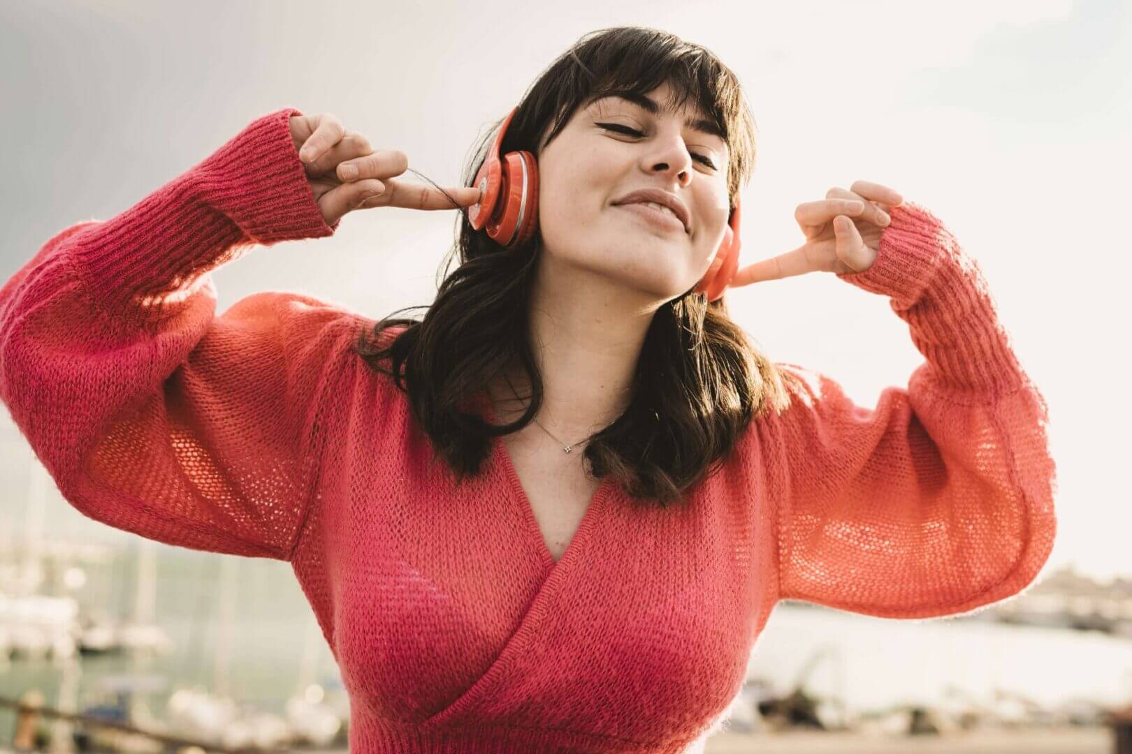 Woman enjoying music with headphones outdoors.
